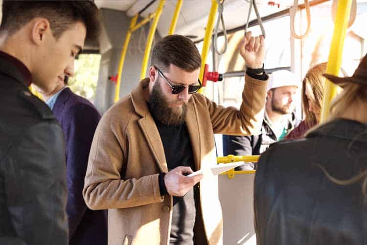 man riding a bus watching video on tablet