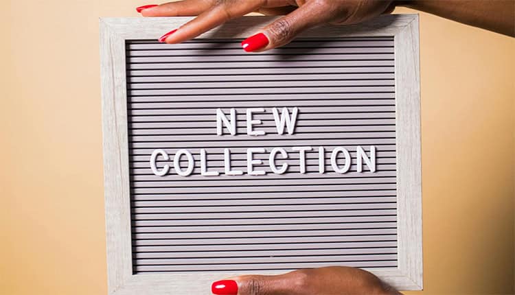 Hands holding a letter board with the text "New Collection" against a beige background.