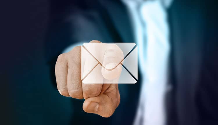 A person in a suit points at a digital envelope icon, symbolizing email communication.