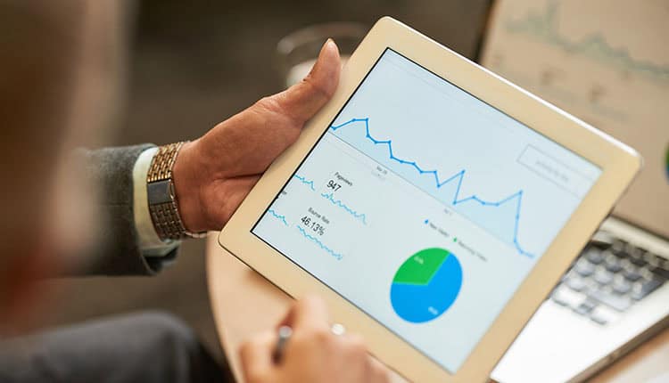 Person viewing graphs and data charts on a tablet screen.