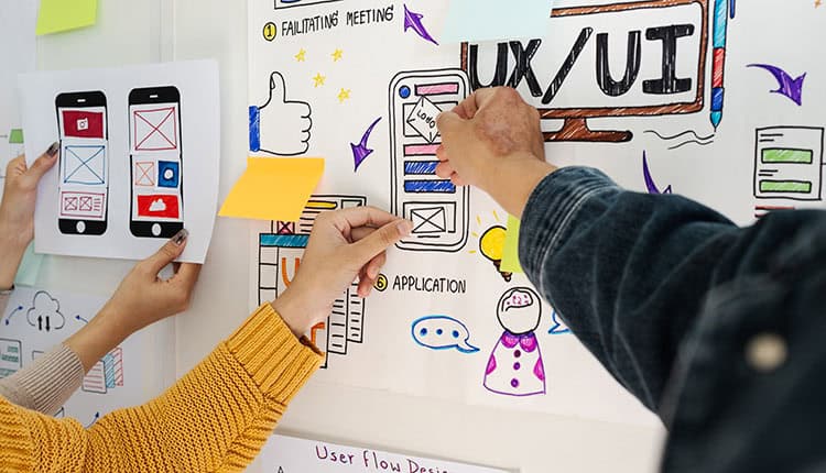 Close up ux developer and ui designer brainstorming interface wireframe design.