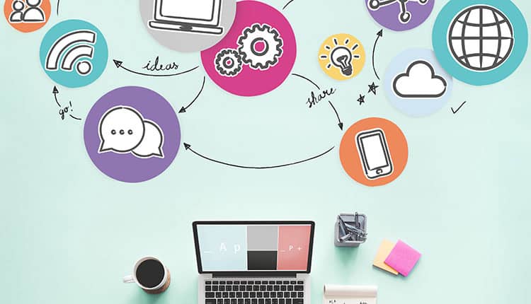 A laptop, coffee cup, notepad, and sticky notes on a desk, with colorful icons above depicting technology, communication, and internet concepts connected by arrows.