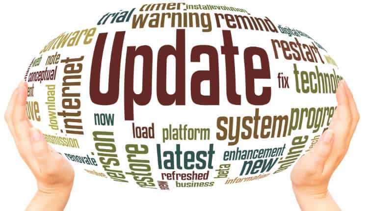 Hands holding a word cloud shaped like an oval, with "Update" in large text at the center, surrounded by technology-related terms like internet, system, latest, restore, and install.